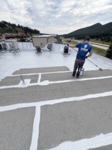 Roof coating being applied to a commercial flat roof system by Guardian Roof Coating in Denver, CO